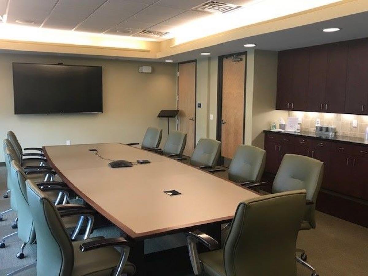 the airport conference room, large table with several chairs, large tv and kitchinette